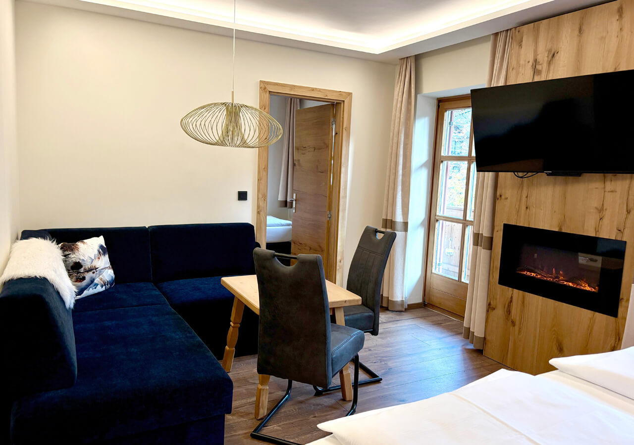 Helles, modernes Familienzimmer mit Doppelbett und Sitzbereich.